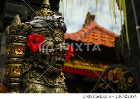 Statue with flowers stands at a temple in Bali, Indonesia Statue with flowers stands at a temple in Bali, Indonesia 136422654
