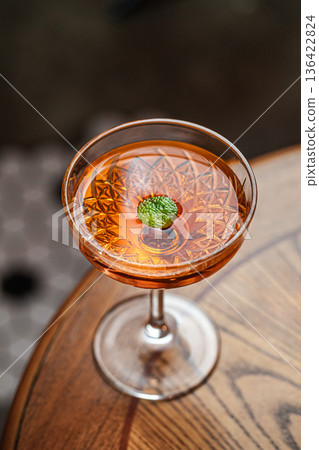 Amber cocktail in coupe glass with garnish Amber cocktail in coupe glass with garnish 136422824