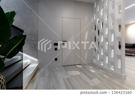 Modern hallway with geometric partition and illuminated stairs Modern hallway with geometric partition and illuminated stairs 136423160