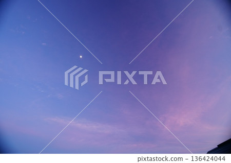 The moon is shining brightly in the sky before dusk, when there is still light remaining. The moon is shining brightly in the sky before dusk, when there is still light remaining. 136424044