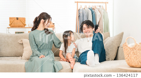 Family relaxing on the sofa at home, family, childcare (affection, family love) 136424117