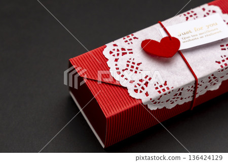 Red gift box on a black background 136424129