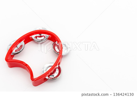 A red tambourine musical instrument placed on a white background A red tambourine musical instrument placed on a white background 136424130