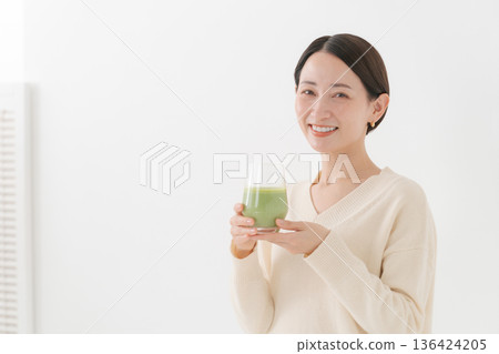 一位女士手持一杯健康飲品 一位女士手持一杯健康飲品 136424205