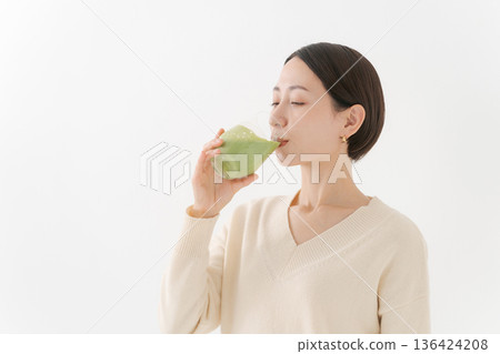 一個女人喝一杯保健飲料 136424208