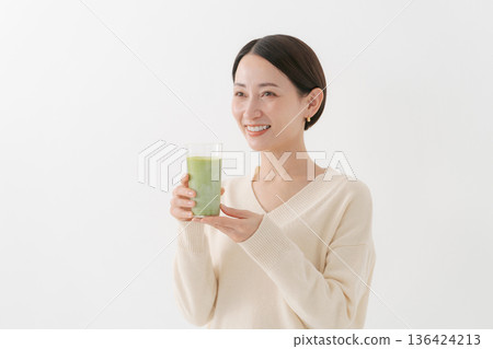 一位女士手持一杯健康飲品 136424213