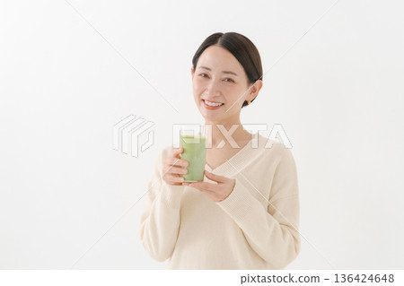 Woman holding a matcha latte 136424648