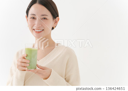Woman holding a matcha latte 136424651