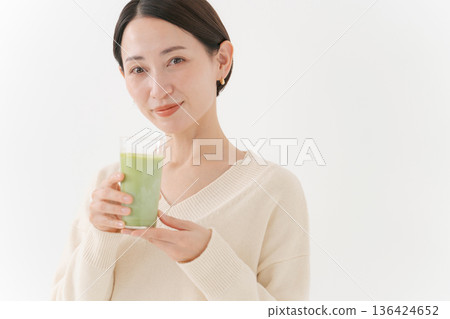 Woman holding a matcha latte 136424652