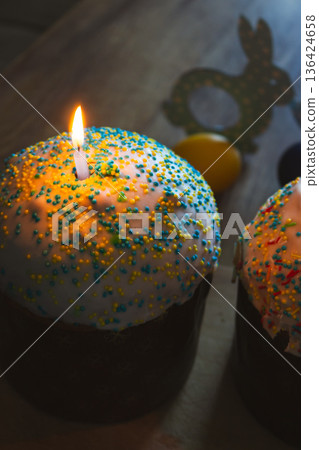 Easter cake with candles and festive decor. Easter still life. Orthodox Eater celebration. Colourful Easter eggs with sweet glazing cakes and lit candles. Spring religious holiday. Christian tradition Easter cake with candles and festive decor. Easter still life. Orthodox Eater celebration. Colourful Easter eggs with sweet glazing cakes and lit candles. Spring religious holiday. Christian tradition 136424658