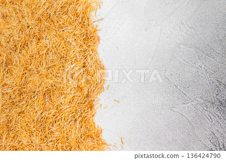 Uncooked kataifi phyllo dough threads for sweet desserts and pastry baking. Rustic flatlay with copy space Uncooked kataifi phyllo dough threads for sweet desserts and pastry baking. Rustic flatlay with copy space 136424790