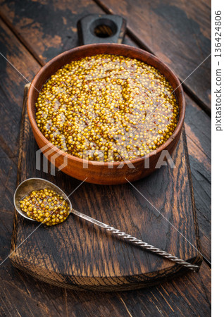 Dijon French mustard with grainy texture in wooden bowl flat lay on wooden background with copy space. 136424806