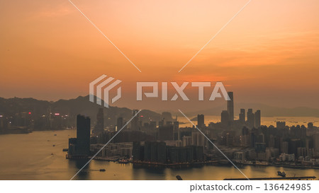 Warm sunset colors illuminate Kowloon skyline and harbourfront Feb 8 2026 136424985