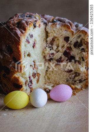 Easter kulich cake with raisins and painted eggs on a table. Easter still life. Orthodox Eater celebration. Colourful eggs with Easter panettone cake with raisins. Spring religious holiday. Easter kulich cake with raisins and painted eggs on a table. Easter still life. Orthodox Eater celebration. Colourful eggs with Easter panettone cake with raisins. Spring religious holiday. 136425365