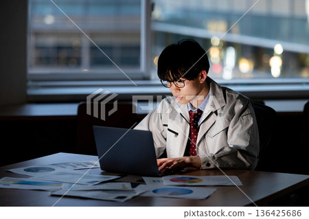 一名身穿工作服的男子正在加班 136425686