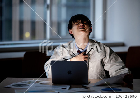 一名身穿工作服的男子正在加班 136425690