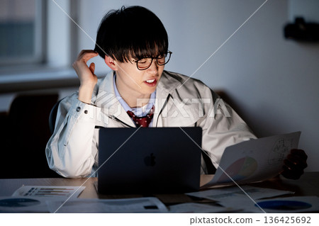 A man in work clothes working overtime 136425692