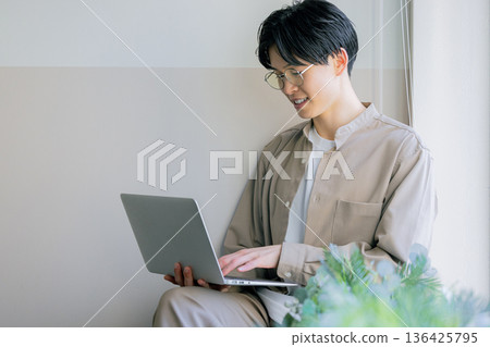 A man working on a computer at home A man working on a computer at home 136425795