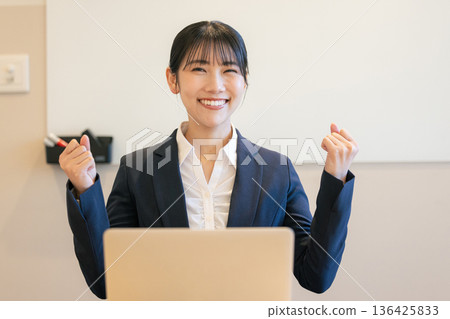 Smiling young woman using a laptop Smiling young woman using a laptop 136425833