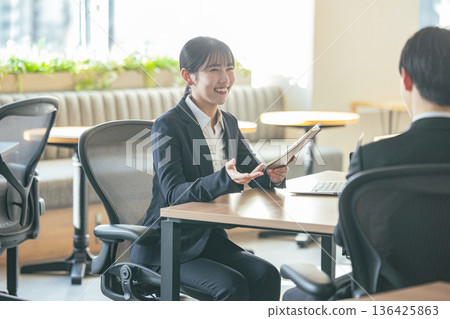 Men and women in suits working in the office 136425863
