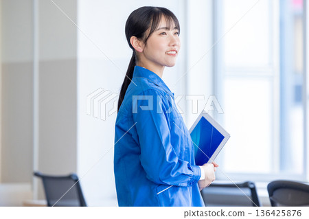 穿著藍色工作服的女人 136425876