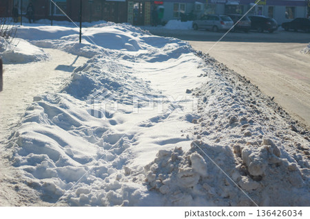 Large snowbank on a city street after heavy snowfall on a sunny winter day 136426034