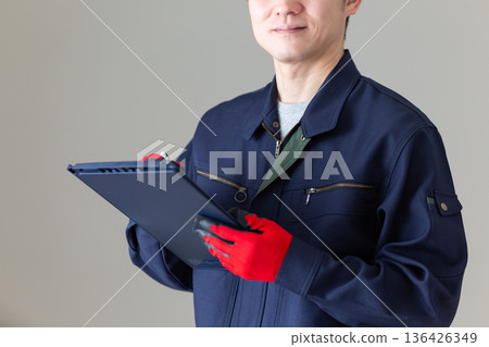 身著工作服的中年男性商務人士，手持活頁夾 136426349