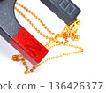 A gold-plated necklace that sticks to a magnet 136426377