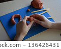 Children clay modeling flat lay step 3 forming small elements and details handmade creative craft educational learning fine motor skills development concept 136426431