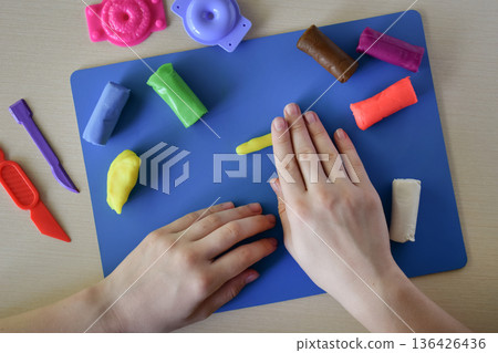 Children creative activity modeling plasticine sweets candy and lollipops flat lay step 2 shaping base forms with hands educational diy craft fine motor skills development playful learning process 136426436