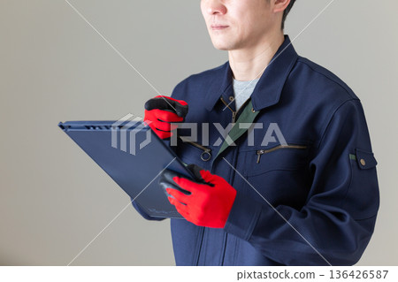 Middle-aged male businessman in work clothes holding a binder Middle-aged male businessman in work clothes holding a binder 136426587