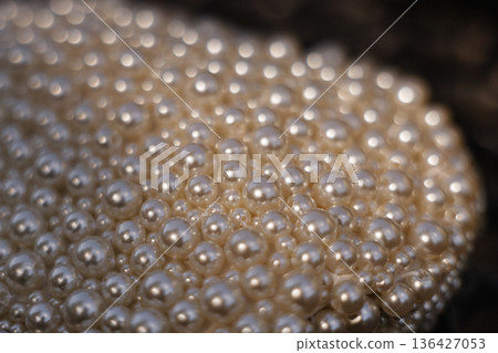 Close-up of a decorative mound of pearl beads on a dark blurred background Close-up of a decorative mound of pearl beads on a dark blurred background 136427053