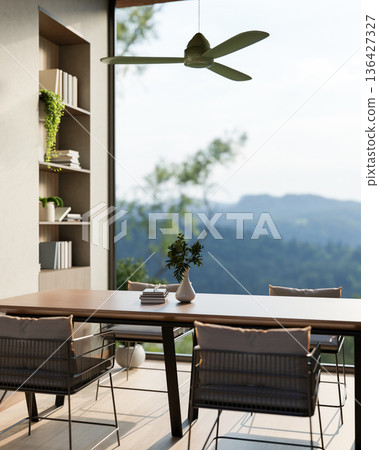 Wooden table and armchairs under ceiling fan aside bookshelf and window wall with a mountain scenery Wooden table and armchairs under ceiling fan aside bookshelf and window wall with a mountain scenery 136427327