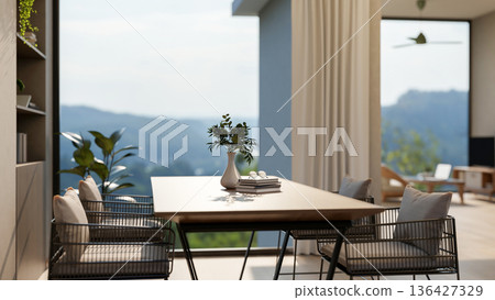 Wooden table and metal armchairs near bookshelf aside window walls and terrace with mountain scenery 136427329