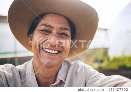 Farming, smile and selfie of woman in greenhouse, sustainable small business and agriculture. Portrait of happy, mature farmer at vegetable farm in summer with growth and development with agro plants Farming, smile and selfie of woman in greenhouse, sustainable small business and agriculture. Portrait of happy, mature farmer at vegetable farm in summer with growth and development with agro plants 136427800