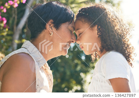 Grandmother, girl and forehead together in garden with eyes closed, connection and bonding with love in summer. Woman, female child and face touch with care, family and relax in sunshine on holiday Grandmother, girl and forehead together in garden with eyes closed, connection and bonding with love in summer. Woman, female child and face touch with care, family and relax in sunshine on holiday 136427897