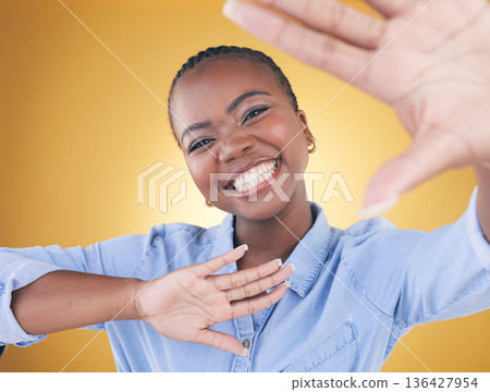 Hands, frame and portrait of black woman in studio smile for confidence, creativity or beauty. Photography, perspective and face of African person on yellow background in cosmetics, makeup or glamour Hands, frame and portrait of black woman in studio smile for confidence, creativity or beauty. Photography, perspective and face of African person on yellow background in cosmetics, makeup or glamour 136427954