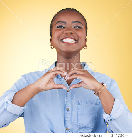 Black woman, heart hands and health with emoji, smile in portrait and love isolated on yellow background. Support, care and kindness with respect, happiness and wellness, romance sign in a studio Black woman, heart hands and health with emoji, smile in portrait and love isolated on yellow background. Support, care and kindness with respect, happiness and wellness, romance sign in a studio 136428094