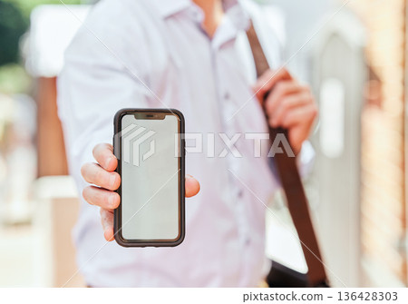 Hand, phone and mockup with a business man in the city on his morning commute into work closeup. Mobile, app or communication with an employee showing blank space on a screen or display outdoor Hand, phone and mockup with a business man in the city on his morning commute into work closeup. Mobile, app or communication with an employee showing blank space on a screen or display outdoor 136428303