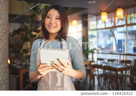 Restaurant, waitress and Asian woman on tablet for order for food service, inventory and sales. Coffee shop, small business and happy person, barista or manager on digital tech for cafe website Restaurant, waitress and Asian woman on tablet for order for food service, inventory and sales. Coffee shop, small business and happy person, barista or manager on digital tech for cafe website 136428322