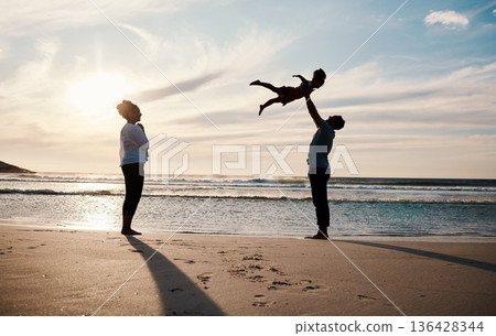 Family, beach and child in air with parents, sunshine with happiness and together with bonding on vacation. Travel, adventure and mother, father and kid flying, happy people in nature with silhouette 136428344