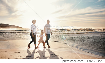 Beach, sunset and family holding hands, walking and bond, relax and happy on vacation in nature together. Travel, love and girl chid with parents at ocean with freedom, adventure or journey in Bali 136428354