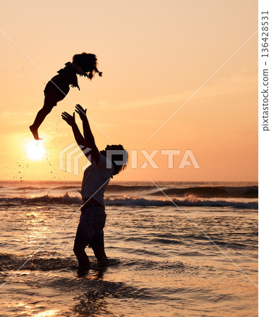 Father, throw and child in air at beach, sunset and waves in the ocean for happiness, fun and support on adventure. Parent, kid and silhouette of dad in the sea with love to play a game with girl Father, throw and child in air at beach, sunset and waves in the ocean for happiness, fun and support on adventure. Parent, kid and silhouette of dad in the sea with love to play a game with girl 136428531