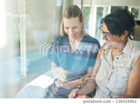 Happy woman, nurse and phone with senior in elderly care for support, consultation or healthcare diagnosis at home. Mature female person and caregiver or medical professional on mobile smartphone app 136428962