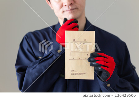 一位身著工作服的中年男商人正為自己的薪水擔憂。 136429500