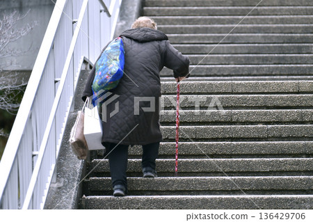 Yokohama cityscape in Japan. Even climbing the stairs is a struggle... steps and unevenness... aging society. Elderly woman with a walking stick = Yokohama city 136429706