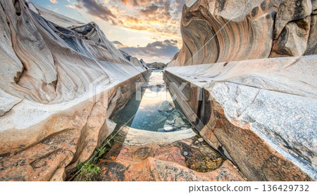 A weathered wooden cross stands before an old door near a mountain tree overlooking a natural greece landscape of flowing river water and stone canyon cliffs under a clear sky 136429732