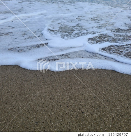 Foam and waves crashing on the sandy beach Foam and waves crashing on the sandy beach 136429797