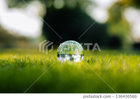 Crystal globe on green grass for environmental sustainability and ecology concept 136430560