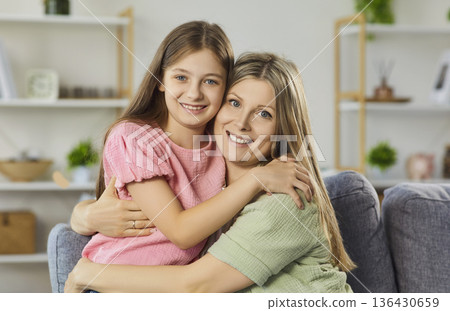 Happy mother hugging daughter at home, close bonding and positive emotions Happy mother hugging daughter at home, close bonding and positive emotions 136430659